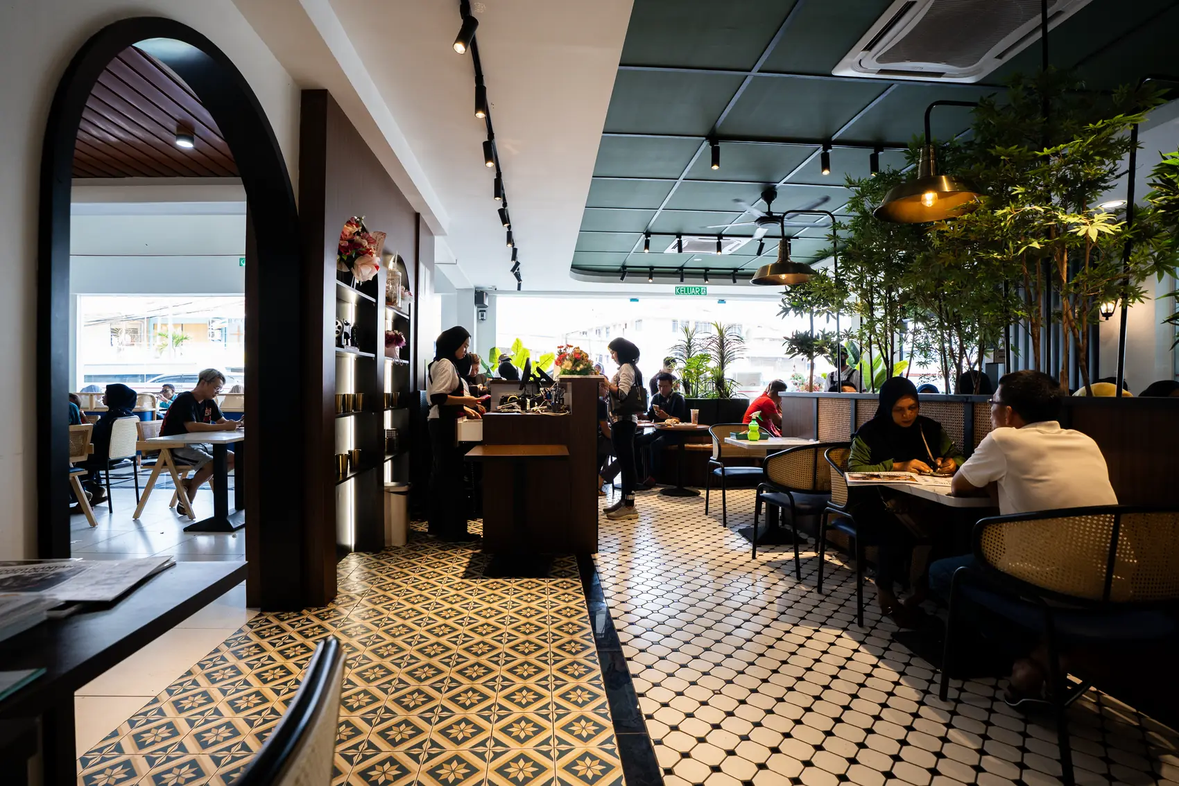Inside a DOJO kopi house: arched doorway, patterned tiles and timber booths